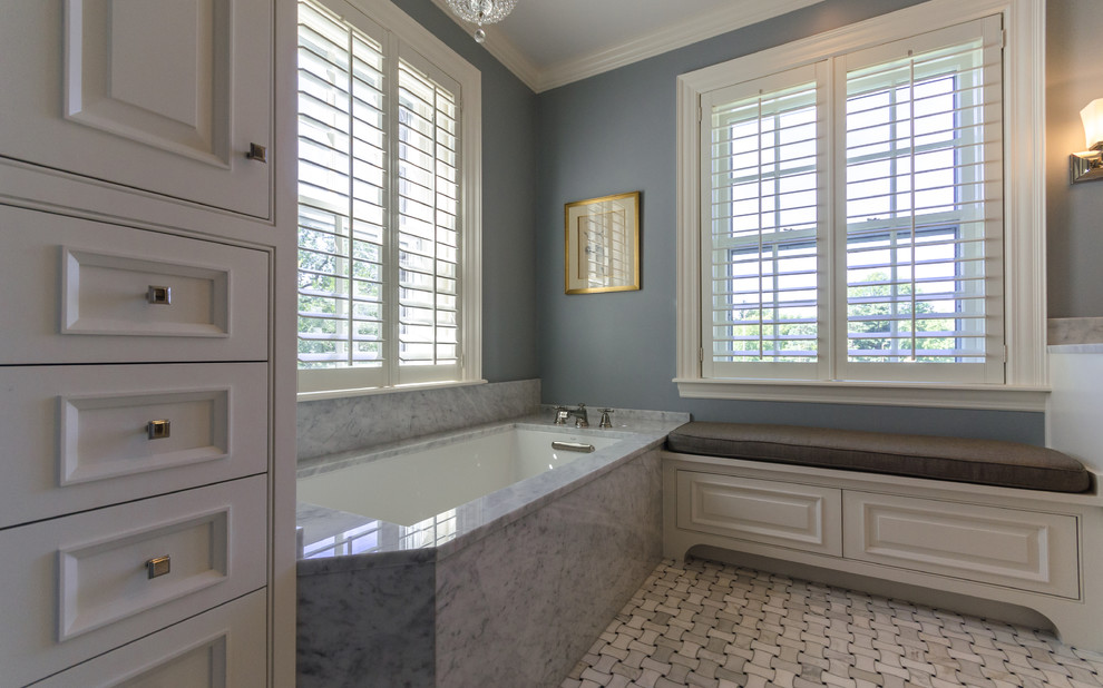 Example of a large classic master alcove bathtub design in Kansas City with raised-panel cabinets, white cabinets and gray walls