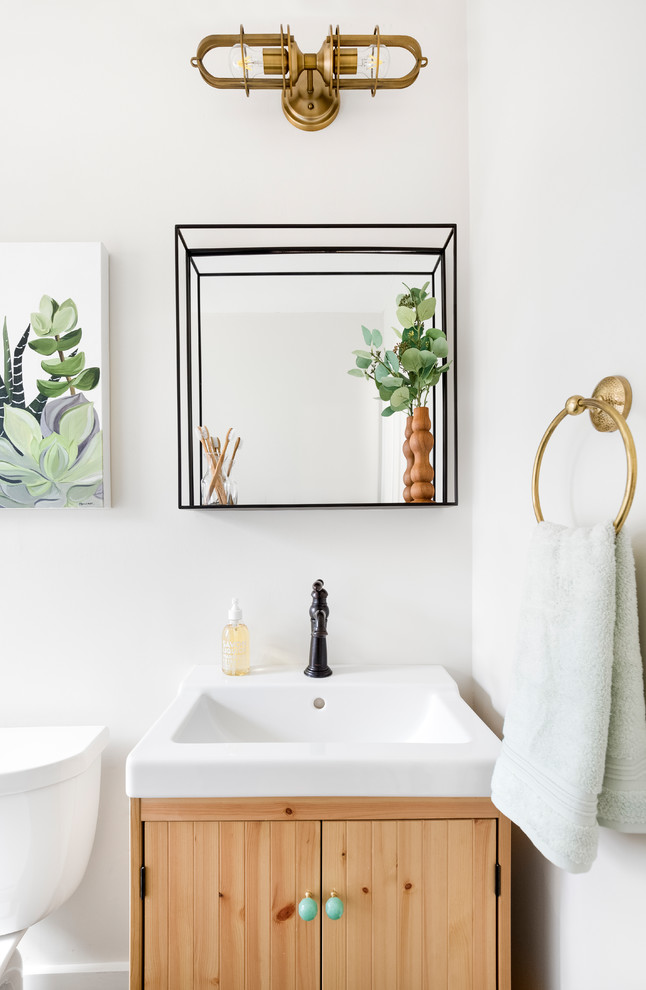 Inspiration for a small modern bathroom in Charlotte with light wood cabinets, an alcove bath, a shower/bath combination, a two-piece toilet, beige walls, marble flooring, an integrated sink, black floors and a shower curtain.
