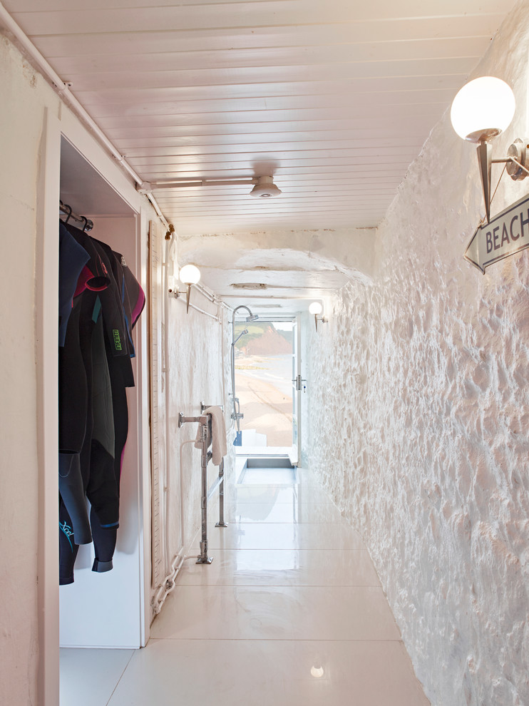 Exemple d'une grande salle de bain bord de mer avec un mur blanc, un sol en carrelage de porcelaine, une douche ouverte et aucune cabine.