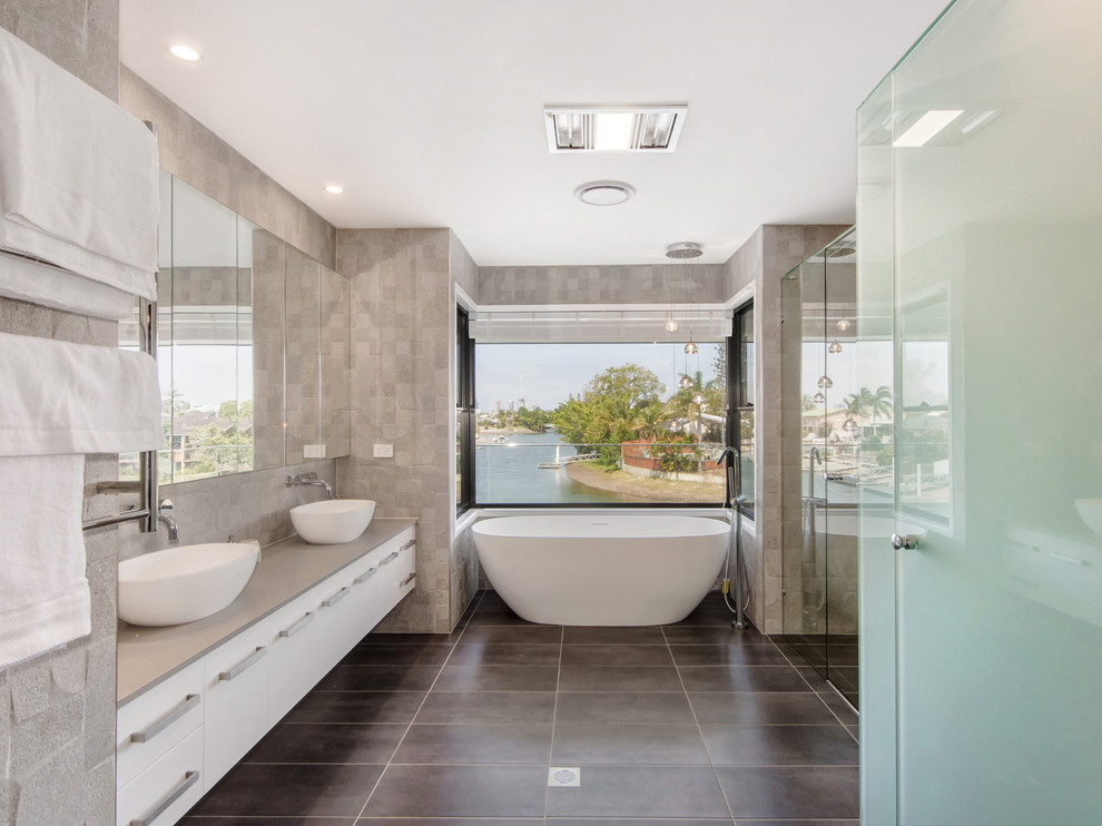 Idee per una stanza da bagno minimalista con ante bianche, piastrelle grigie, top in granito e top beige