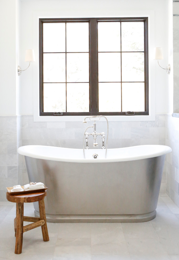 На фото: большая главная ванная комната в стиле неоклассика (современная классика) с отдельно стоящей ванной, угловым душем, серой плиткой и белыми стенами