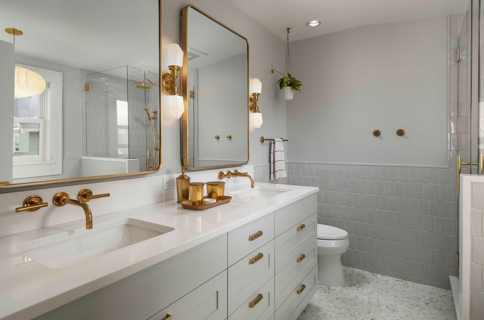Bathroom - mid-sized transitional master gray tile and ceramic tile mosaic tile floor and gray floor bathroom idea in Portland with recessed-panel cabinets, gray cabinets, a one-piece toilet, gray walls, an undermount sink, quartzite countertops, a hinged shower door and white countertops