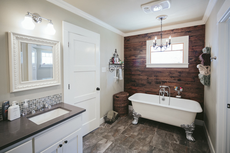 Réalisation d'une salle de bain tradition avec des portes de placard blanches, une baignoire sur pieds et un mur beige.
