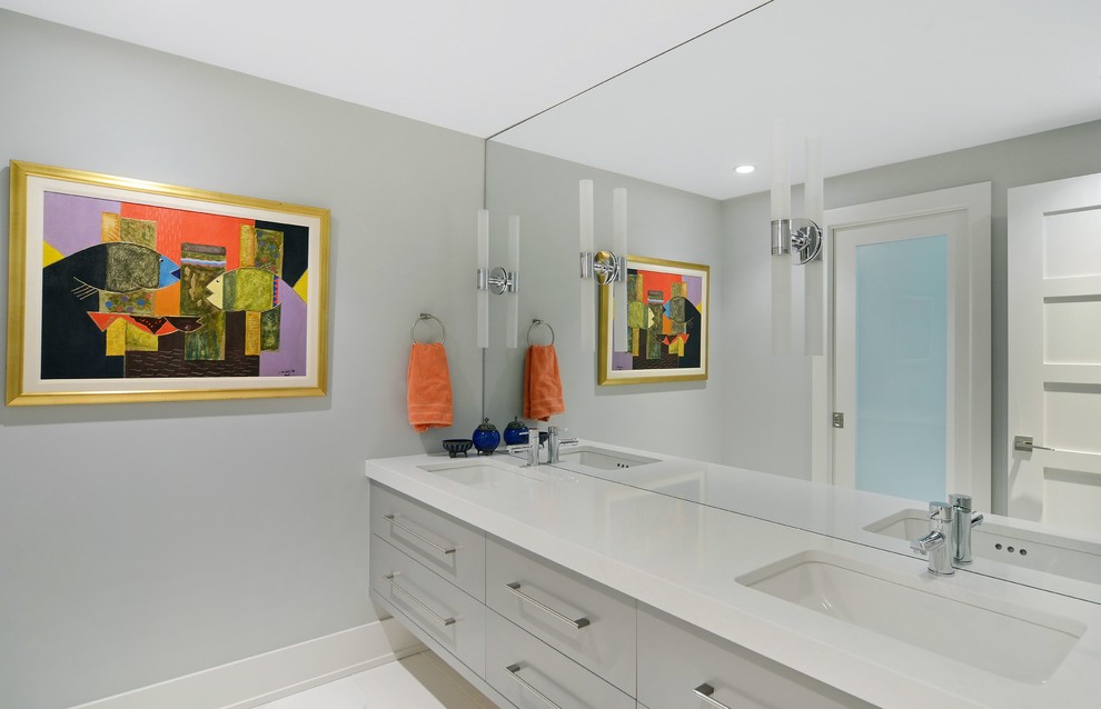 Réalisation d'une salle de bain design avec un placard à porte plane, des portes de placard grises, un mur gris, un lavabo encastré et un plan de toilette en quartz.