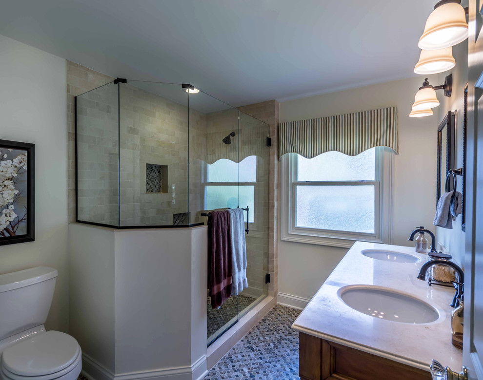 Стильный дизайн: главная ванная комната среднего размера в классическом стиле с фасадами с выступающей филенкой, фасадами цвета дерева среднего тона, угловым душем, раздельным унитазом, белой плиткой, каменной плиткой, белыми стенами, полом из мозаичной плитки, врезной раковиной, мраморной столешницей, разноцветным полом, душем с распашными дверями, белой столешницей, зеркалом с подсветкой, тумбой под две раковины, подвесной тумбой, потолком с обоями и обоями на стенах - последний тренд