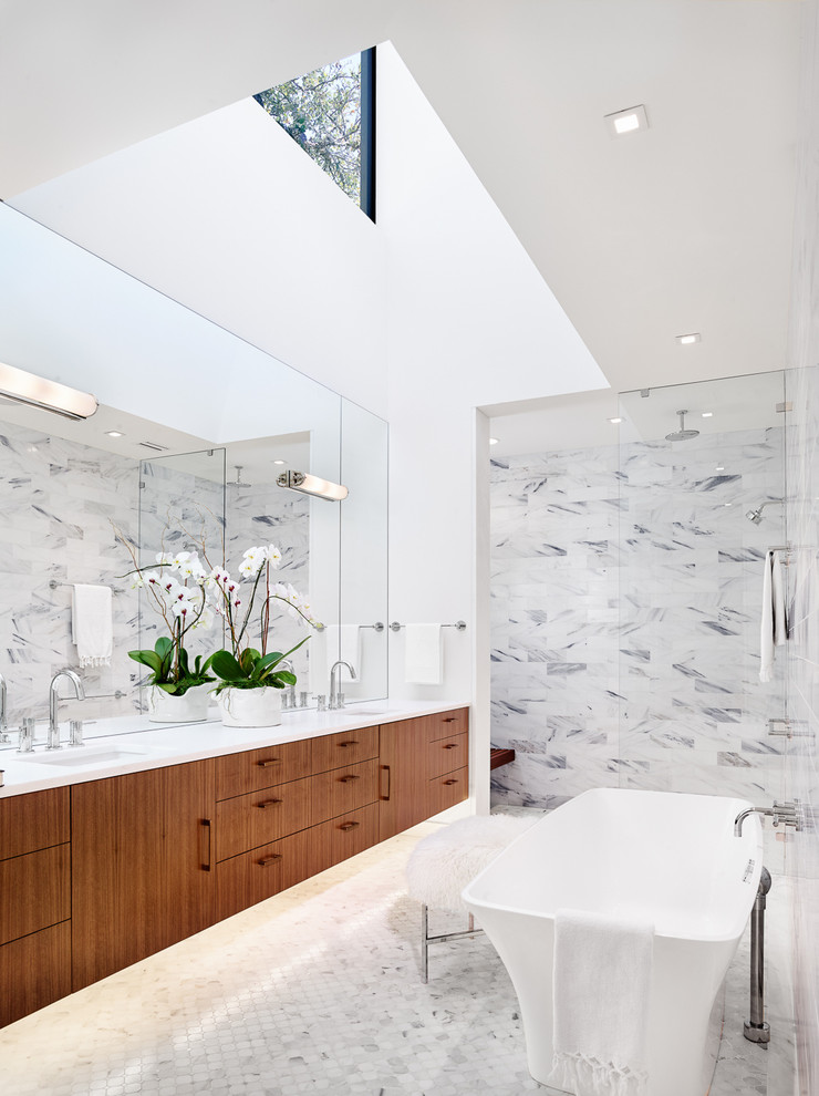 Inspiration för moderna badrum, med ett undermonterad handfat, släta luckor, skåp i mörkt trä, ett fristående badkar, vit kakel, vita väggar och mosaikgolv