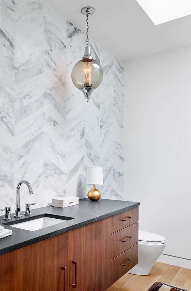 Example of a trendy white tile medium tone wood floor bathroom design in Austin with an undermount sink, flat-panel cabinets, dark wood cabinets, white walls and gray countertops