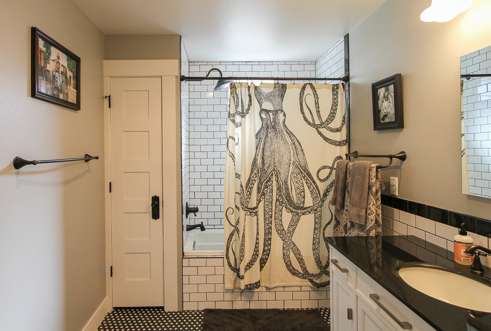 Inspiration for a mid-sized transitional 3/4 white tile and subway tile black floor bathroom remodel in Denver with recessed-panel cabinets, white cabinets, gray walls, an undermount sink, solid surface countertops and black countertops