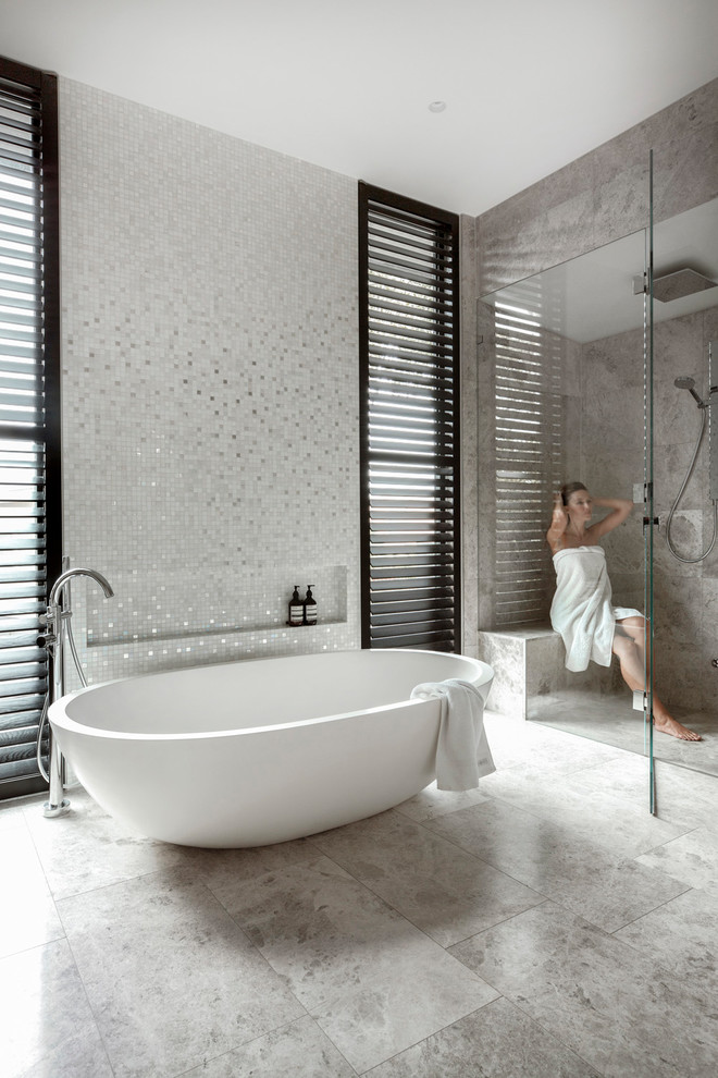 Inredning av ett modernt en-suite badrum, med ett fristående badkar, en dubbeldusch, marmorkakel och marmorbänkskiva