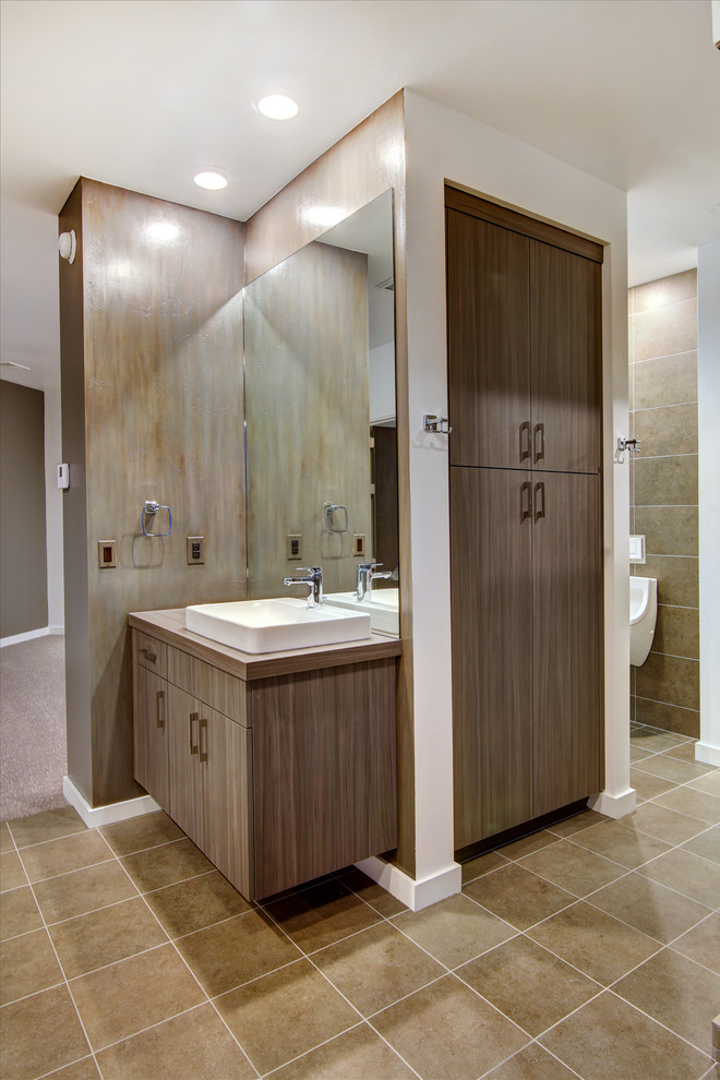 Exemple d'une salle d'eau tendance en bois brun de taille moyenne avec un placard à porte plane, WC séparés, un carrelage blanc, des carreaux de porcelaine, un mur gris, sol en béton ciré, une vasque et un plan de toilette en bois.