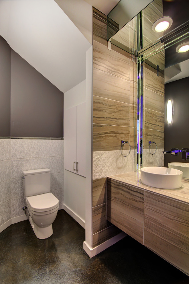 Bild på ett mellanstort funkis badrum med dusch, med släta luckor, skåp i mellenmörkt trä, en toalettstol med separat cisternkåpa, vit kakel, porslinskakel, grå väggar, betonggolv, ett fristående handfat och träbänkskiva
