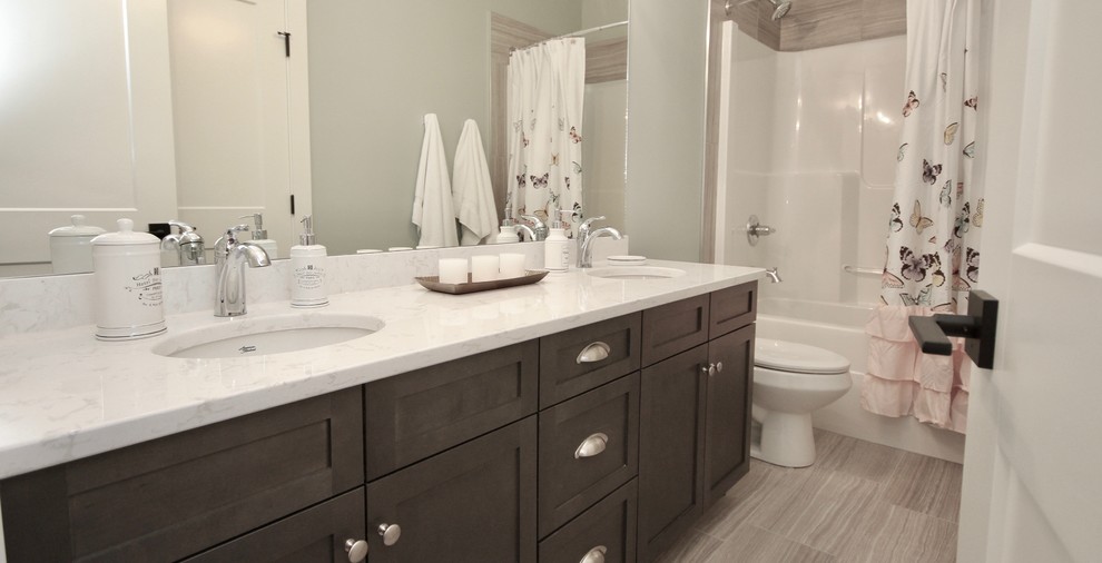 Foto på ett mellanstort vintage vit badrum för barn, med skåp i shakerstil, skåp i mörkt trä, ett badkar i en alkov, en dusch/badkar-kombination, brun kakel, grå väggar, klinkergolv i keramik, ett undermonterad handfat, marmorbänkskiva, brunt golv och dusch med duschdraperi