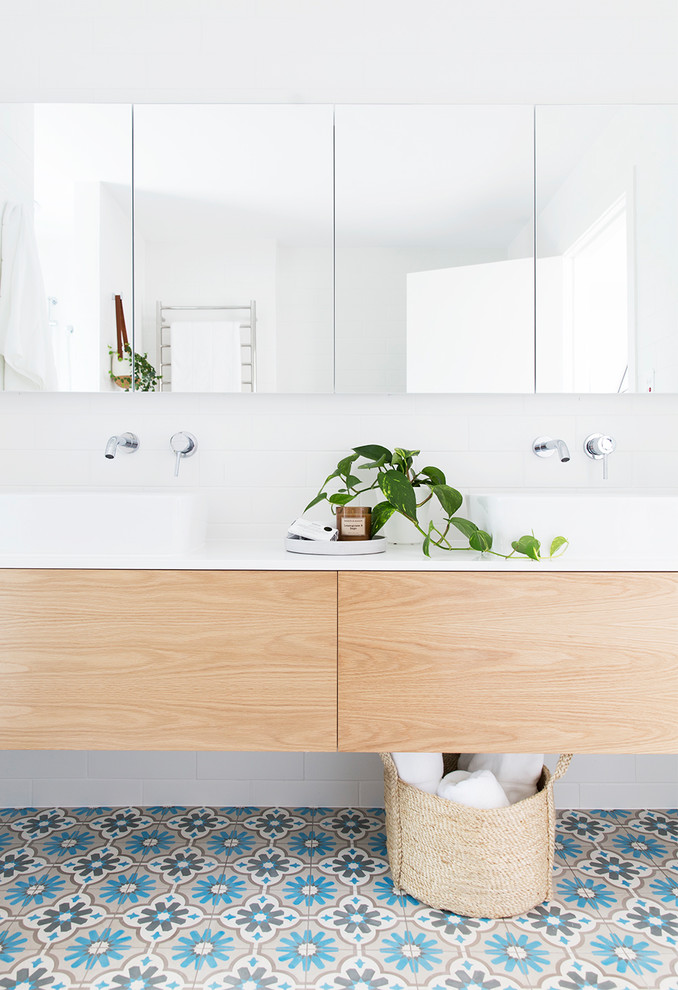 Maritimes Badezimmer mit flächenbündigen Schrankfronten, hellen Holzschränken, weißer Wandfarbe, Porzellan-Bodenfliesen, Aufsatzwaschbecken und Pflanzen in Brisbane