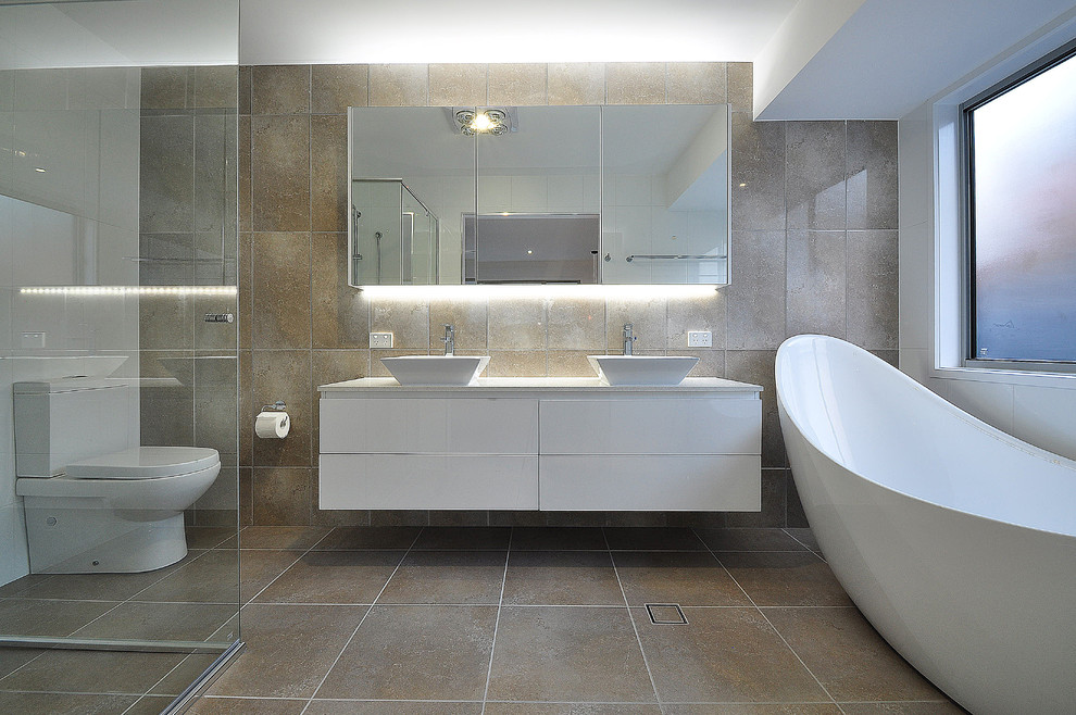 Inspiration för ett funkis badrum, med ett fristående handfat, vita skåp, ett fristående badkar och klinkergolv i porslin