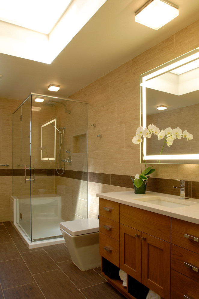 Cette photo montre une petite salle de bain tendance en bois clair avec un lavabo encastré, un placard à porte plane, un plan de toilette en quartz modifié, une baignoire posée, WC à poser, un carrelage beige, des carreaux de porcelaine, un mur beige et un sol en carrelage de porcelaine.