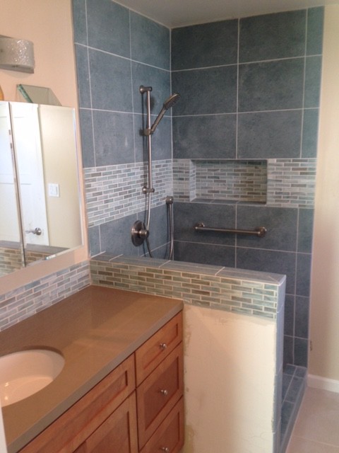 Photo of a small contemporary family bathroom in San Francisco with shaker cabinets, medium wood cabinets, a corner shower, a two-piece toilet, blue tiles, porcelain tiles, beige walls, porcelain flooring, quartz worktops and a submerged sink.