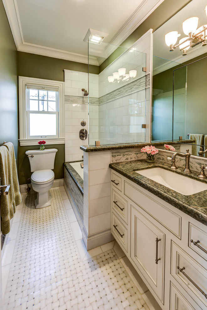 Tub/shower combo - mid-sized traditional kids' white tile and stone tile mosaic tile floor tub/shower combo idea in San Francisco with beaded inset cabinets, white cabinets, an undermount tub, a two-piece toilet, green walls, an undermount sink and granite countertops