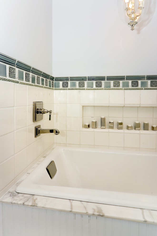 Réalisation d'une salle de bain tradition avec une baignoire posée et un carrelage blanc.