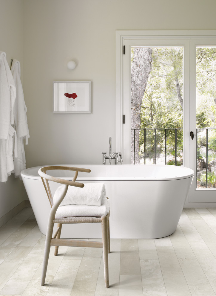 Modelo de cuarto de baño principal contemporáneo de tamaño medio con bañera exenta, baldosas y/o azulejos blancos, baldosas y/o azulejos de porcelana, paredes blancas y suelo de baldosas de porcelana