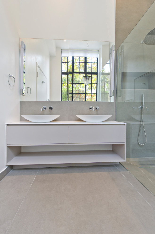 Inspiration för mellanstora moderna vitt en-suite badrum, med släta luckor, grå skåp, ett fristående badkar, våtrum, en vägghängd toalettstol, grå kakel, keramikplattor, grå väggar, klinkergolv i keramik, ett konsol handfat, träbänkskiva, grått golv och med dusch som är öppen