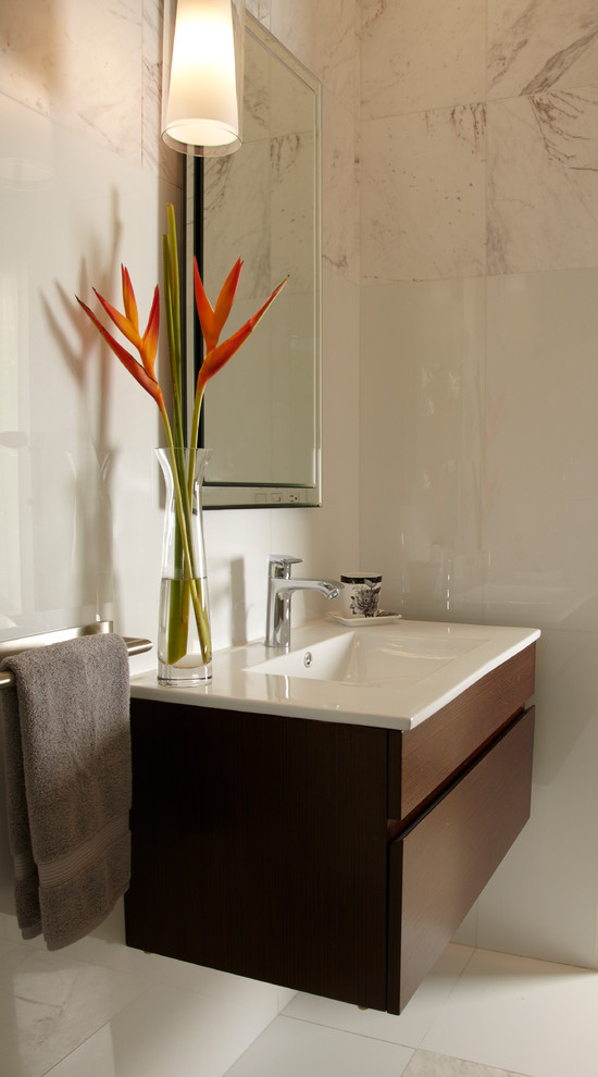 This is an example of a small contemporary bathroom in Miami with flat-panel cabinets, dark wood cabinets, a one-piece toilet, multi-coloured tiles, marble tiles, multi-coloured walls, marble flooring, an integrated sink, engineered stone worktops and white floors.