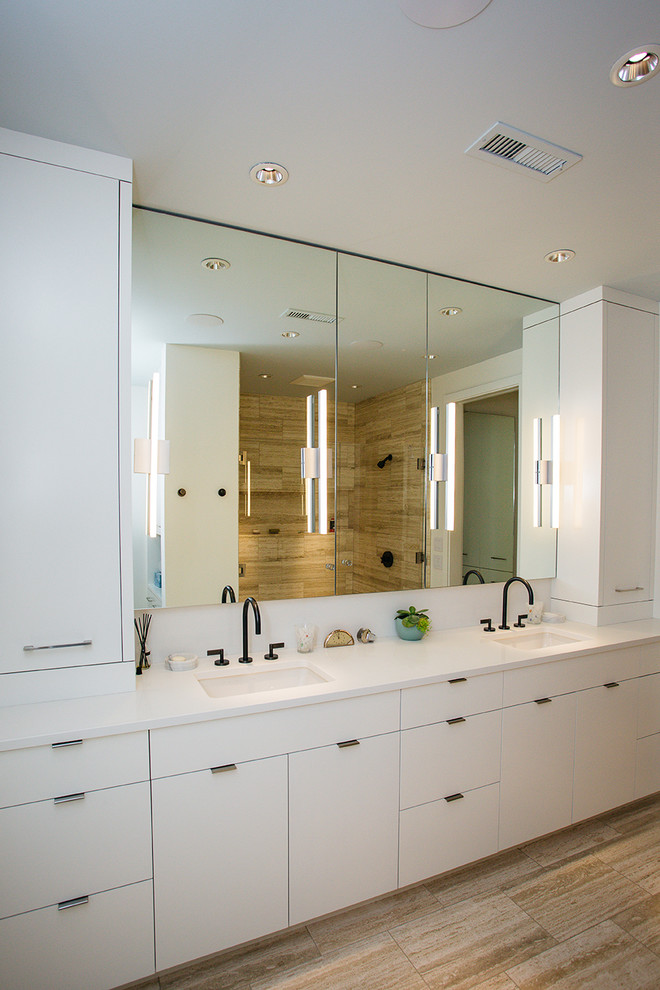 Modern inredning av ett mellanstort vit vitt en-suite badrum, med vita skåp, en kantlös dusch, vita väggar, laminatgolv, ett undermonterad handfat, brunt golv och dusch med gångjärnsdörr