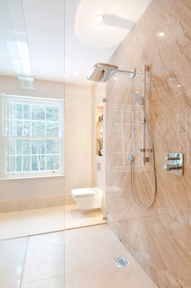 Idee per una stanza da bagno contemporanea con doccia a filo pavimento, lastra di pietra, WC sospeso e piastrelle beige