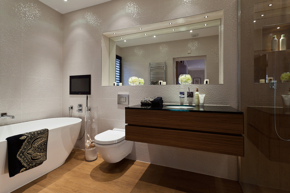 Réalisation d'une salle de bain design en bois foncé avec un lavabo encastré, un placard à porte plane, une baignoire indépendante, WC suspendus et un carrelage blanc.