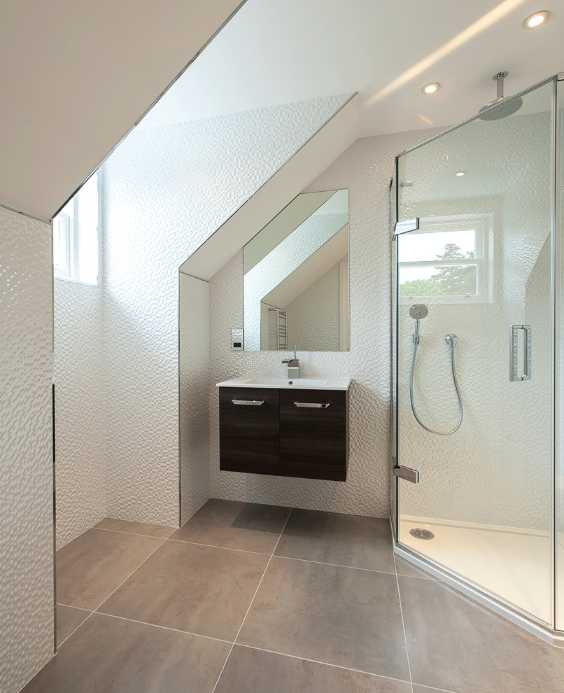 На фото: ванная комната в современном стиле с монолитной раковиной, плоскими фасадами, черными фасадами, угловым душем и белой плиткой с