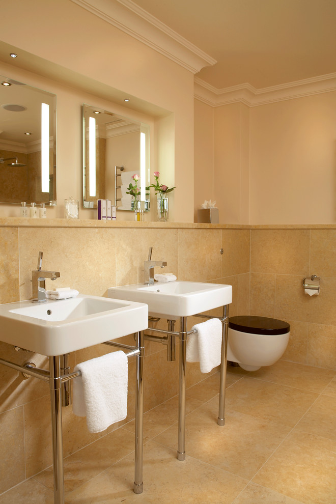 Imagen de cuarto de baño clásico renovado con sanitario de pared, lavabo tipo consola y espejo con luz