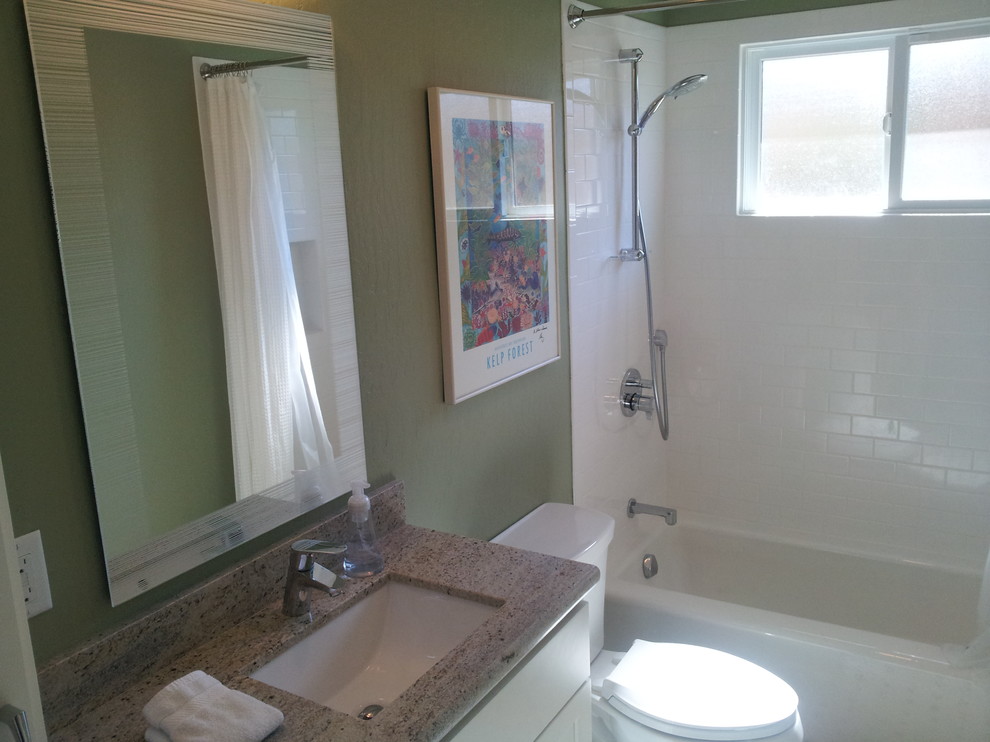 Cette image montre une grande salle de bain design avec un lavabo encastré, un placard à porte shaker, des portes de placard blanches, un plan de toilette en granite, une baignoire en alcôve, WC séparés, un carrelage blanc, des carreaux de porcelaine, un combiné douche/baignoire, un mur vert et un sol en carrelage de céramique.