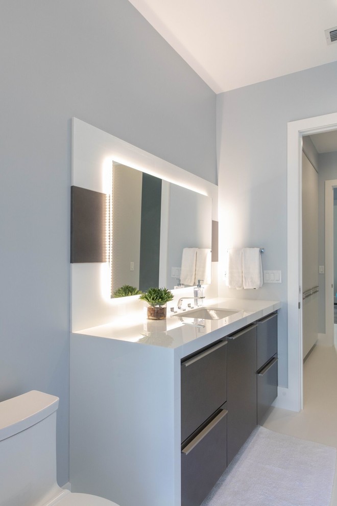 Inspiration pour une salle de bain design de taille moyenne avec un placard à porte plane, WC à poser, un mur bleu, un sol en carrelage de porcelaine, un lavabo encastré, un plan de toilette en quartz modifié, un sol blanc, un plan de toilette blanc, des portes de placard grises et des dalles de pierre.