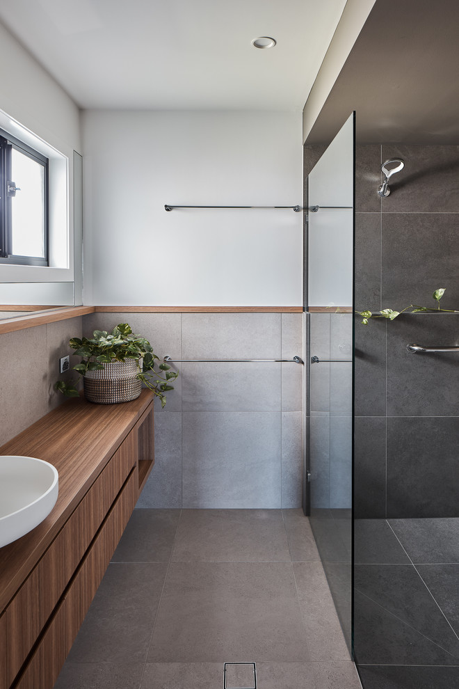 Inspiration for a medium sized beach style family bathroom in Gold Coast - Tweed with medium wood cabinets, a built-in bath, a walk-in shower, grey tiles, porcelain tiles, white walls, porcelain flooring, a vessel sink, laminate worktops, grey floors, an open shower and brown worktops.