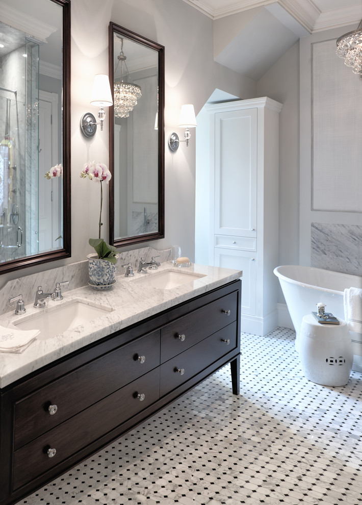 This is an example of a classic bathroom in Toronto with a submerged sink, marble worktops, a freestanding bath, grey tiles, mosaic tiles, freestanding cabinets, grey walls, marble flooring and dark wood cabinets.