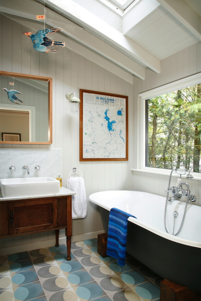 Klassisches Badezimmer mit freistehender Badewanne, beigen Fliesen, blauen Fliesen, grauen Fliesen, weißer Wandfarbe, Aufsatzwaschbecken und Schrankfronten im Shaker-Stil in London