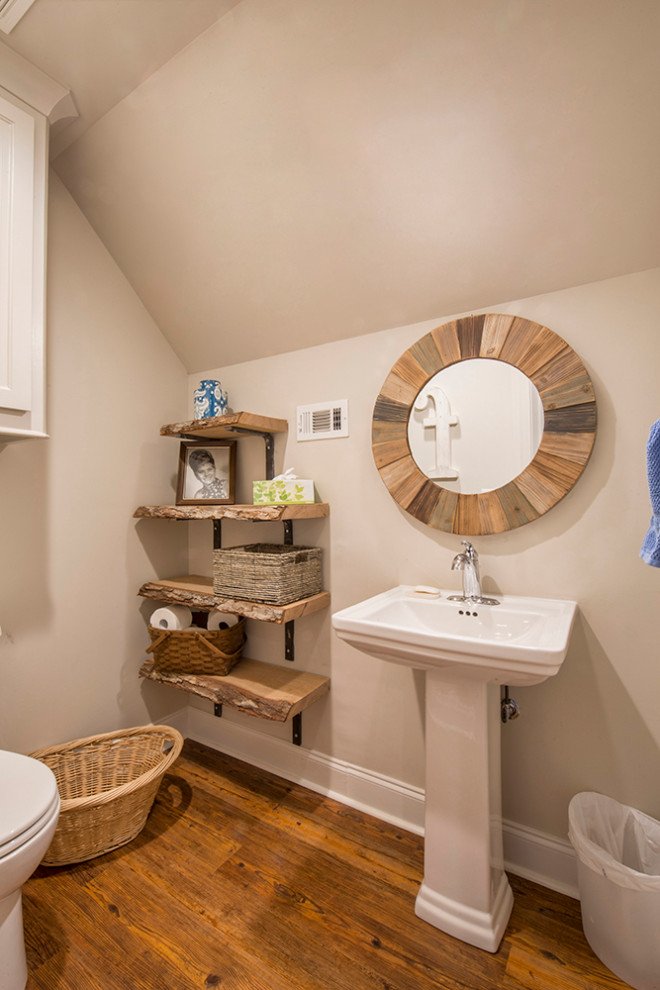Inredning av ett rustikt litet badrum för barn, med öppna hyllor, en toalettstol med separat cisternkåpa, beige väggar, vinylgolv, ett piedestal handfat och brunt golv