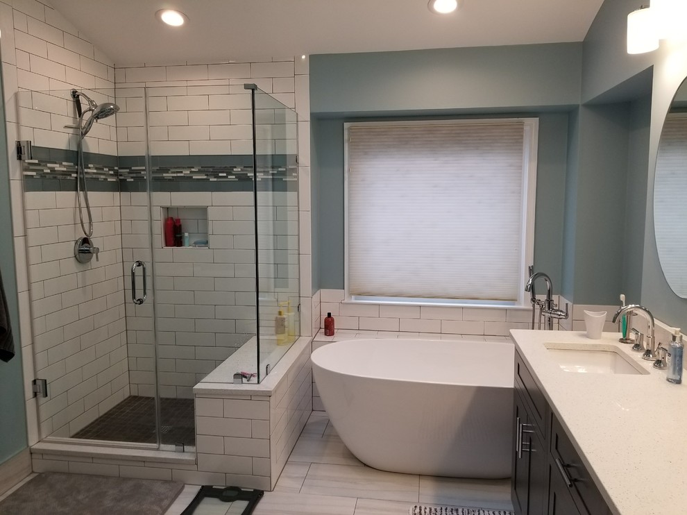 Modern inredning av ett mellanstort vit vitt en-suite badrum, med skåp i shakerstil, bruna skåp, ett fristående badkar, en hörndusch, vit kakel, porslinskakel, blå väggar, klinkergolv i porslin, ett undermonterad handfat, bänkskiva i kvarts, flerfärgat golv och dusch med gångjärnsdörr