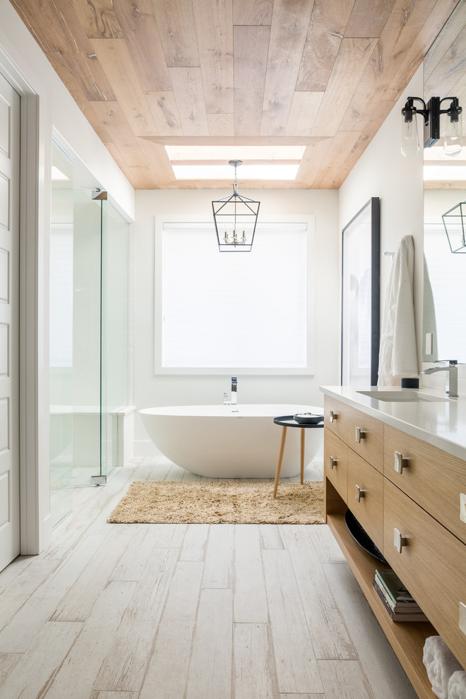 Inspiration för stora moderna vitt en-suite badrum, med släta luckor, skåp i ljust trä, ett fristående badkar, våtrum, vit kakel, keramikplattor, vita väggar, ljust trägolv, ett nedsänkt handfat, träbänkskiva, vitt golv och dusch med skjutdörr