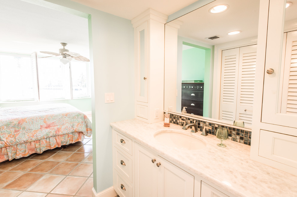 Example of a mid-sized beach style 3/4 beige tile, black and white tile, brown tile and mosaic tile alcove shower design in Miami with recessed-panel cabinets, white cabinets, a two-piece toilet, green walls, an undermount sink and granite countertops