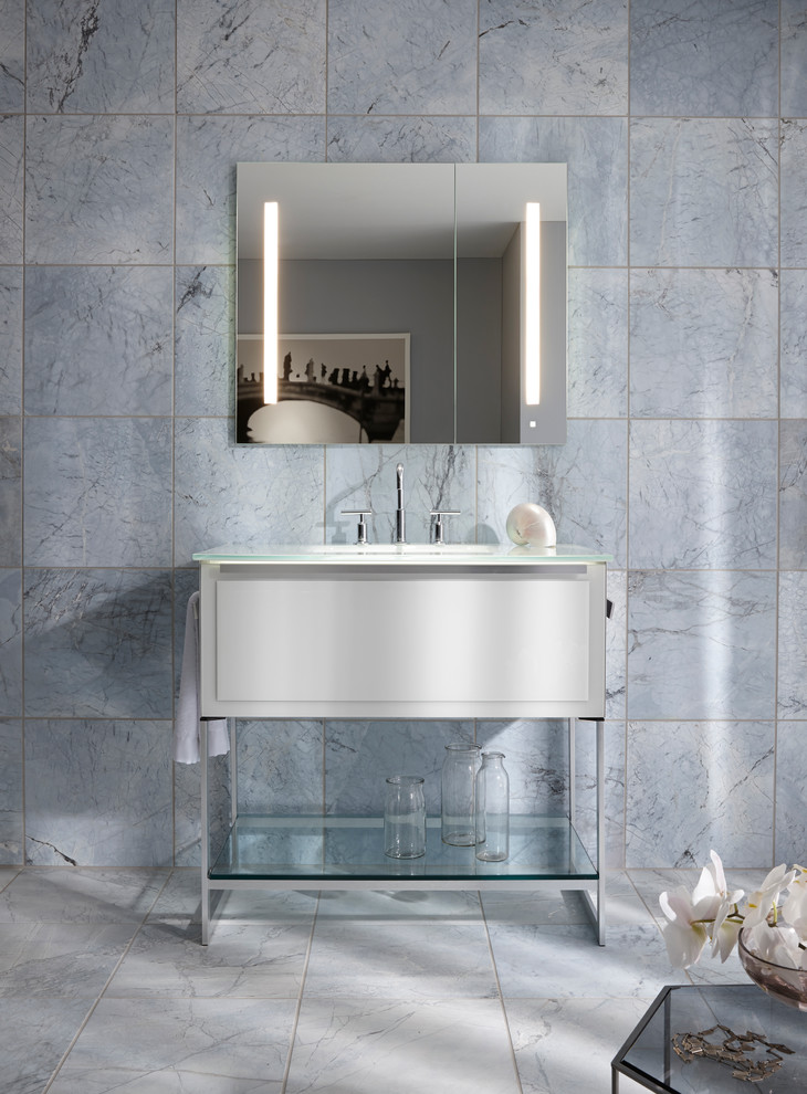 Modelo de cuarto de baño costero con baldosas y/o azulejos azules, baldosas y/o azulejos de piedra, lavabo integrado y encimera de vidrio