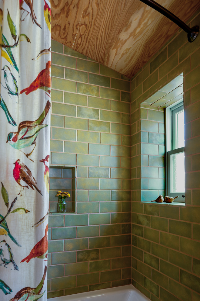 Cette image montre une salle de bain chalet de taille moyenne avec une baignoire posée, un combiné douche/baignoire, un carrelage vert, des carreaux de céramique et une cabine de douche avec un rideau.