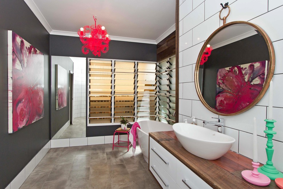 Inspiration för mellanstora moderna en-suite badrum, med träbänkskiva, ett fristående badkar, vit kakel, tunnelbanekakel, ett fristående handfat, vita skåp, en öppen dusch, svarta väggar och klinkergolv i porslin