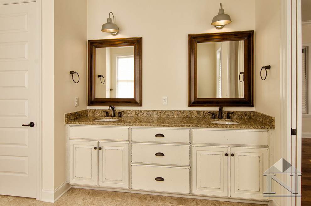 Example of a large arts and crafts master beige tile and ceramic tile ceramic tile bathroom design in Charlotte with an undermount sink, raised-panel cabinets, distressed cabinets, granite countertops, a one-piece toilet and beige walls
