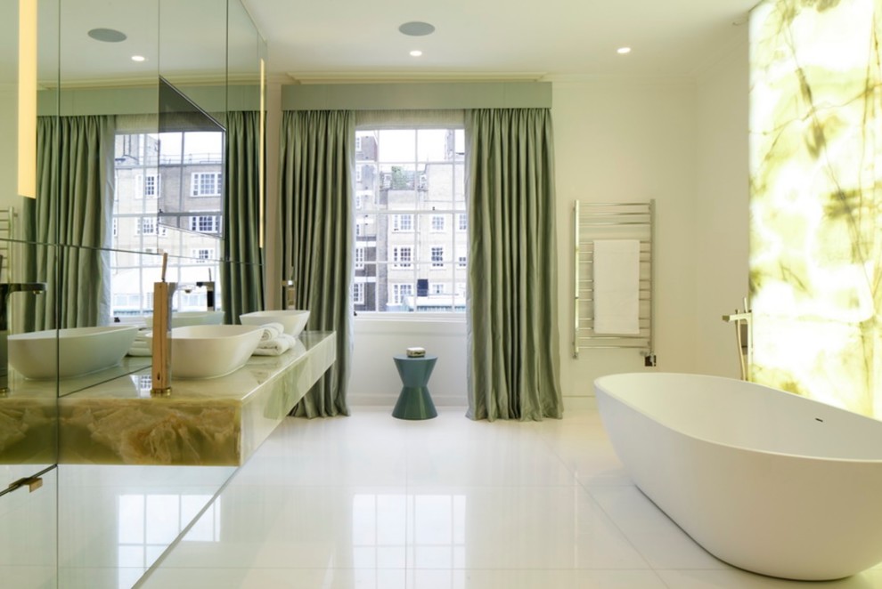 Design ideas for a large contemporary bathroom in London with a freestanding bath, mirror tiles, a vessel sink, white floors, white walls and green worktops.