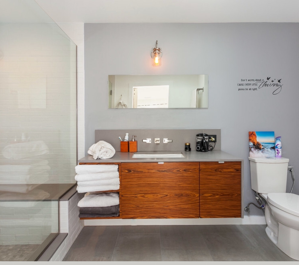 Photo of a medium sized contemporary ensuite wet room bathroom in Los Angeles with flat-panel cabinets, medium wood cabinets, a two-piece toilet, grey walls, a submerged sink, engineered stone worktops and grey worktops.
