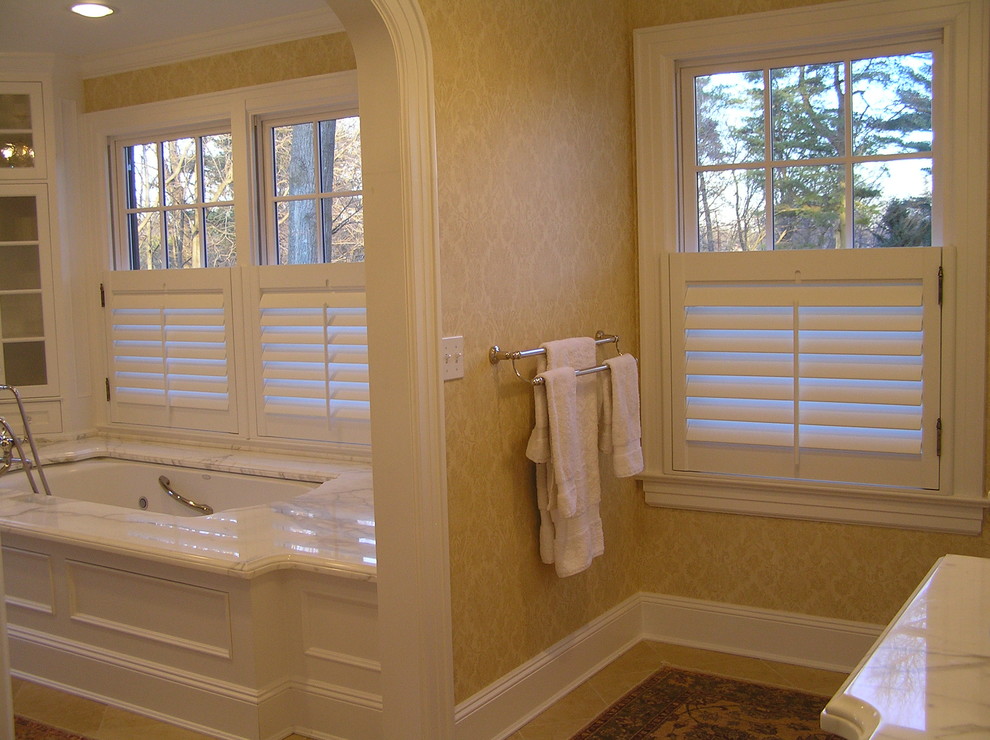 Стильный дизайн: большая главная ванная комната в классическом стиле с стеклянными фасадами, белыми фасадами, ванной в нише, бежевыми стенами, полом из керамической плитки и мраморной столешницей - последний тренд