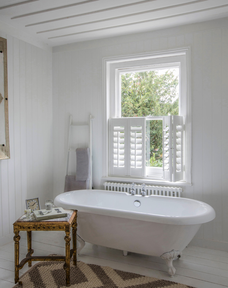 Foto di una stanza da bagno stile marinaro con vasca con piedi a zampa di leone, pavimento in legno verniciato e pavimento bianco