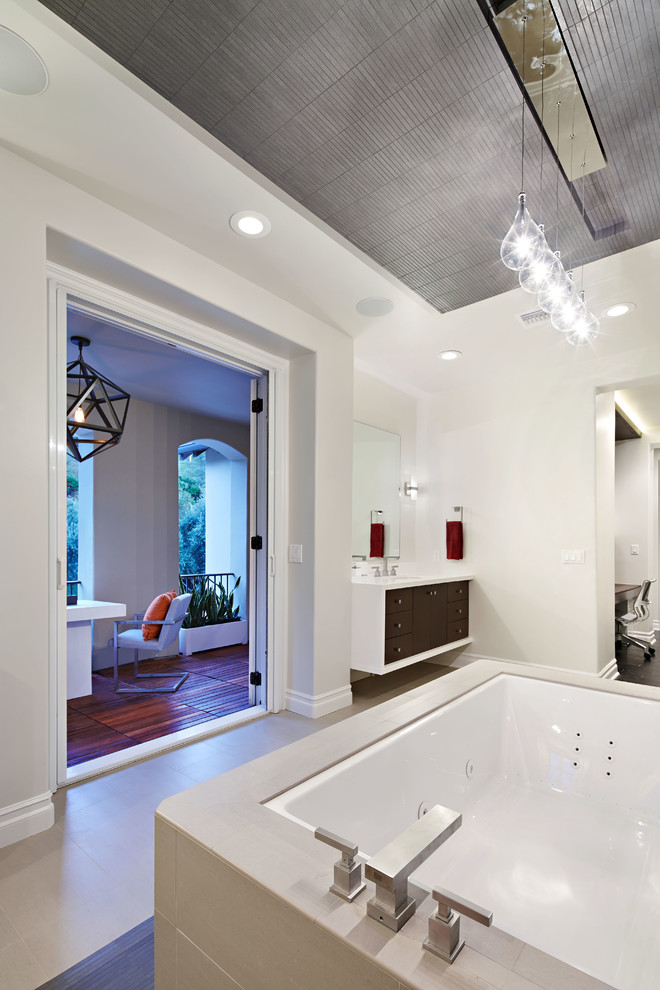 Cette photo montre une salle de bain tendance avec un placard à porte plane et une baignoire encastrée.