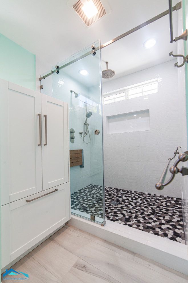 Источник вдохновения для домашнего уюта: большая ванная комната в современном стиле с фасадами в стиле шейкер, белыми фасадами, душем в нише, унитазом-моноблоком, белой плиткой, зелеными стенами, полом из ламината, душевой кабиной, врезной раковиной, столешницей из гранита, бежевым полом и душем с раздвижными дверями