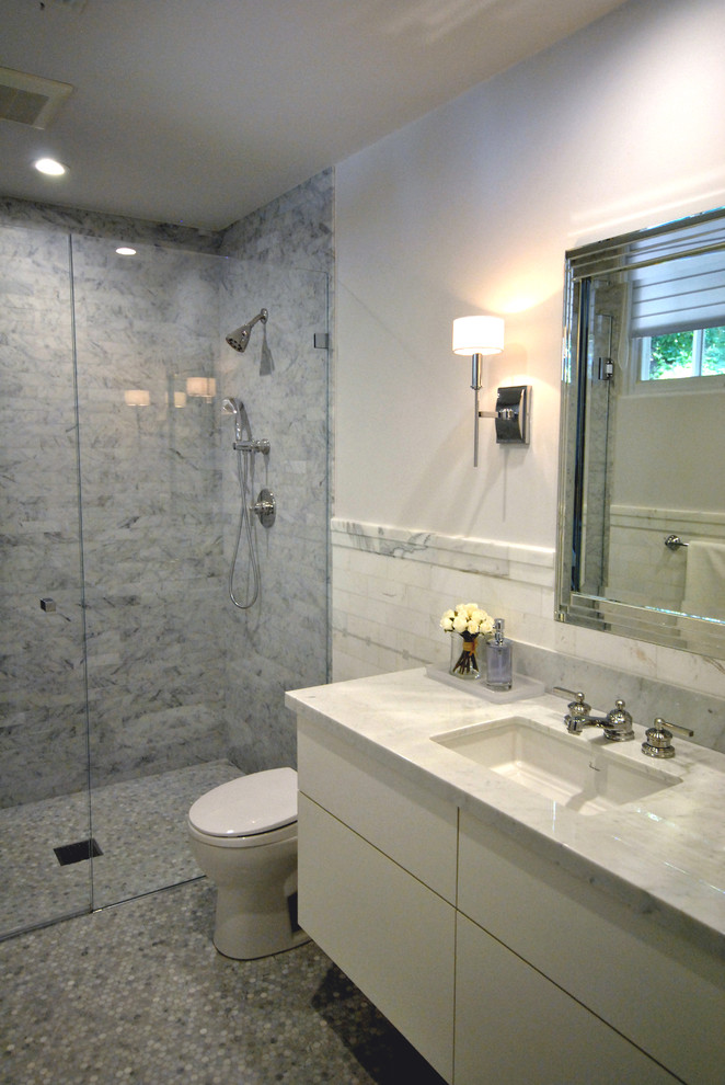 Idéer för ett modernt badrum med dusch, med släta luckor, vita skåp, en kantlös dusch, en toalettstol med hel cisternkåpa, vit kakel, marmorkakel, vita väggar, ett undermonterad handfat, marmorbänkskiva, grått golv och dusch med gångjärnsdörr